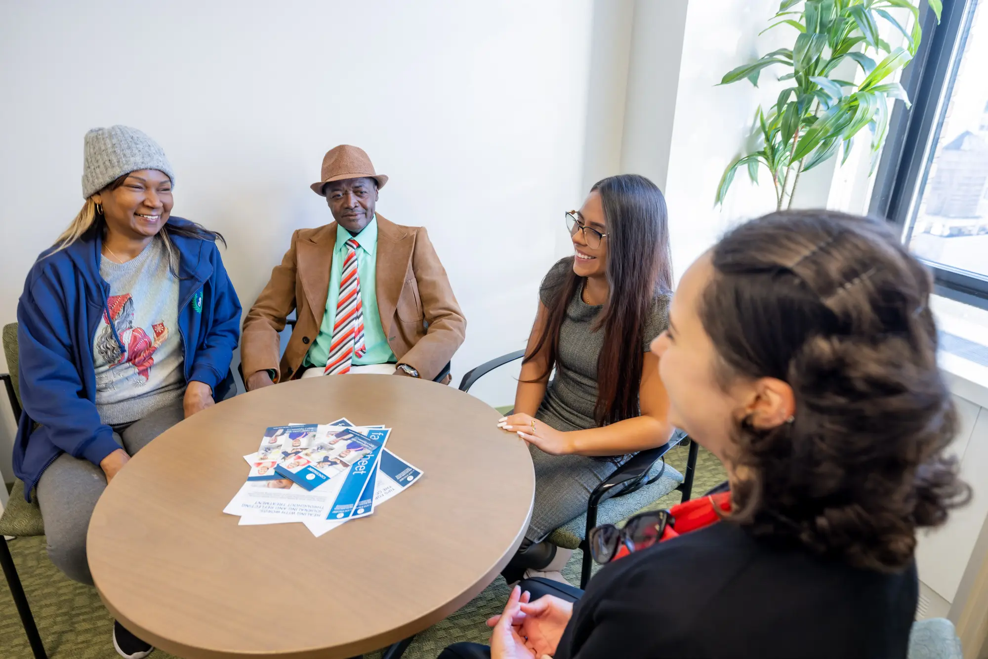 support group sitting at a table with a social worker