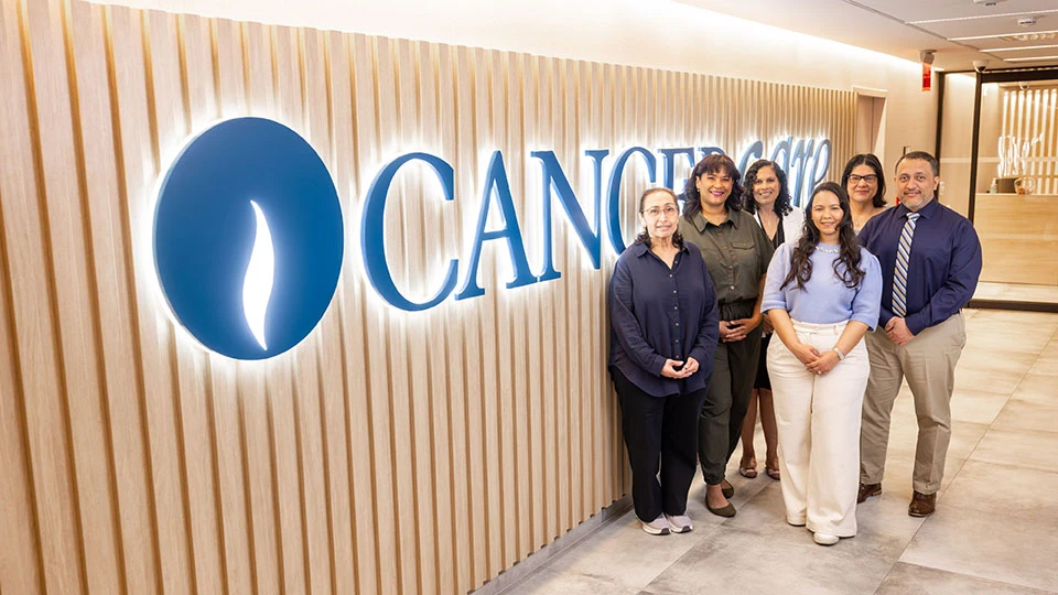 Group of social workers standing in front of CancerCare sign